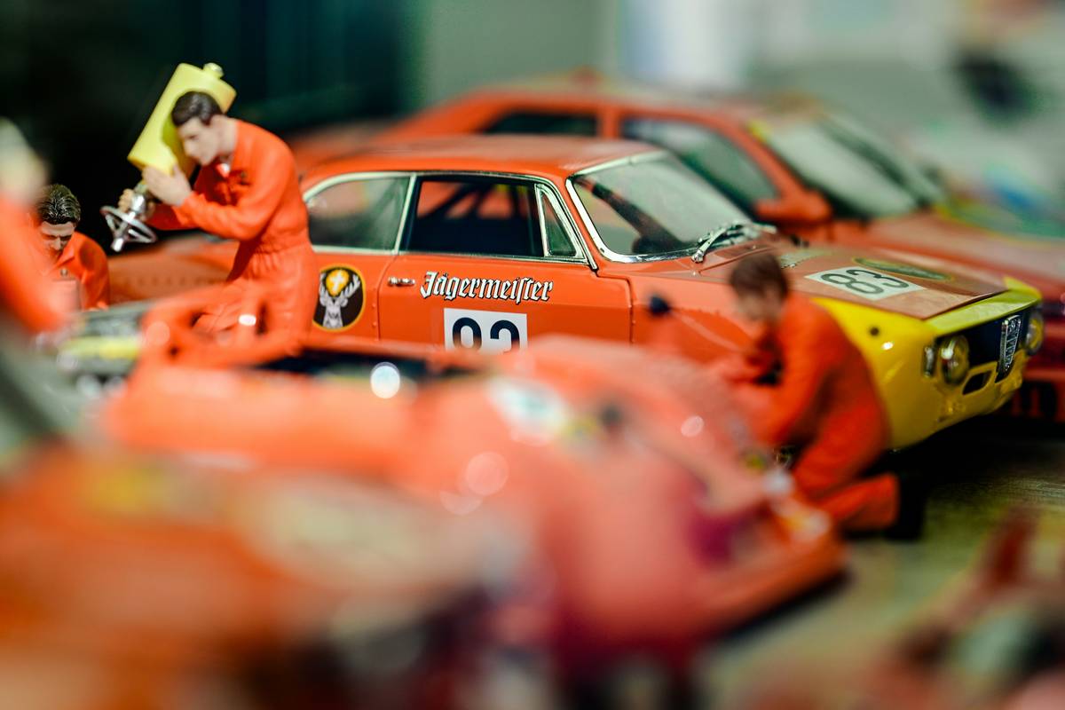 Close-up of adult hands assembling a slot car racing for adults track with precision tools